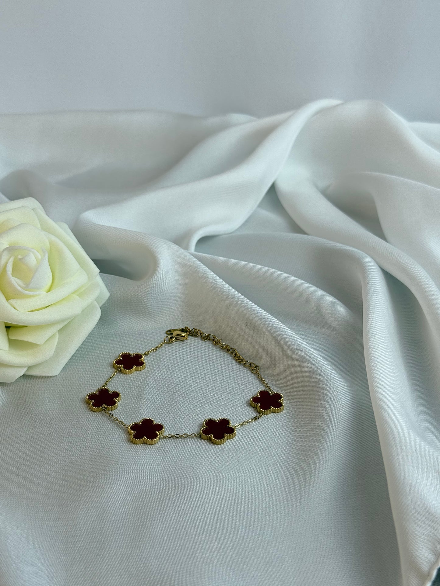 Bracelet with flower-shaped charms on a white fabric background