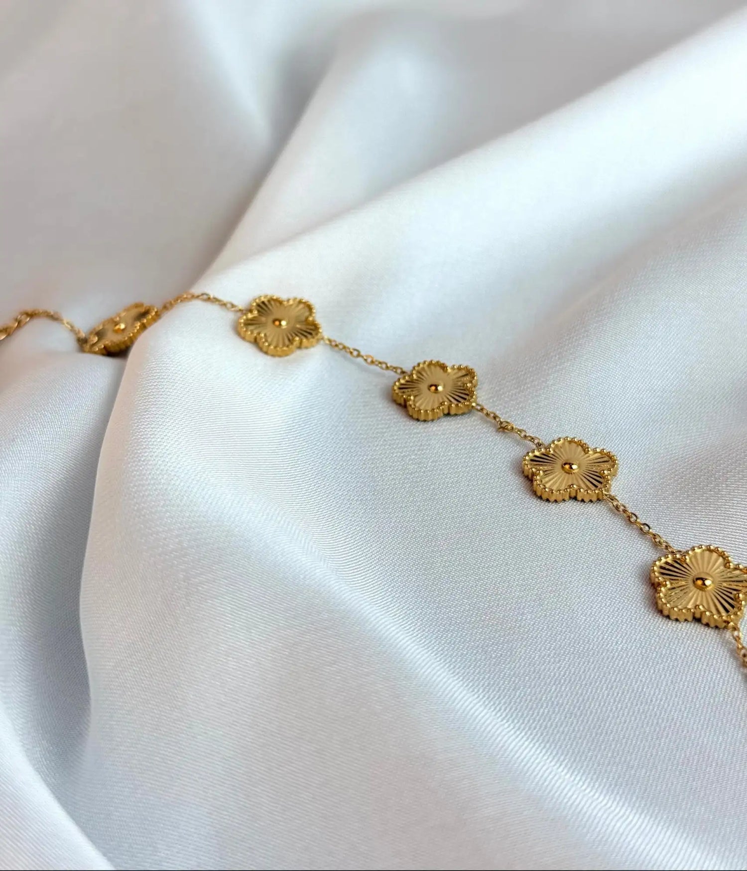 Golden floral link bracelet with intricate petal detailing and a polished finish.