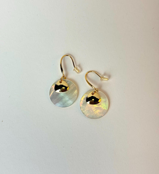 Gold earrings with round, light-colored stones on a white background