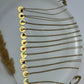 Gold necklaces with various pendants on a white plate