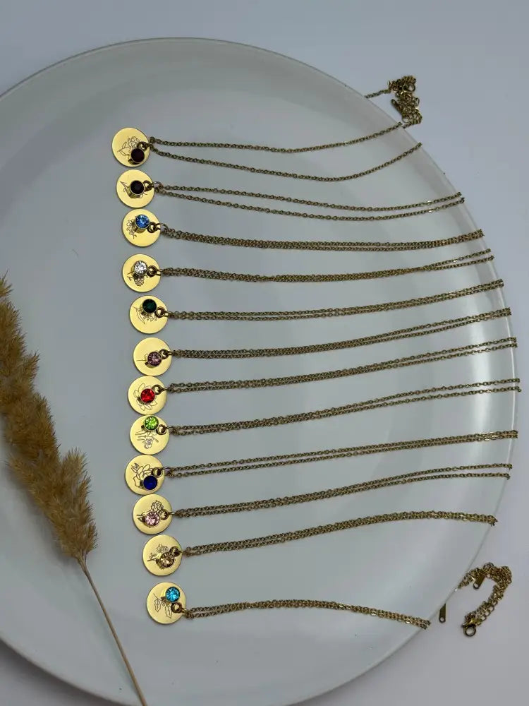 Gold necklaces with various pendants on a white plate
