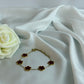Bracelet with flower-shaped charms on a white fabric background