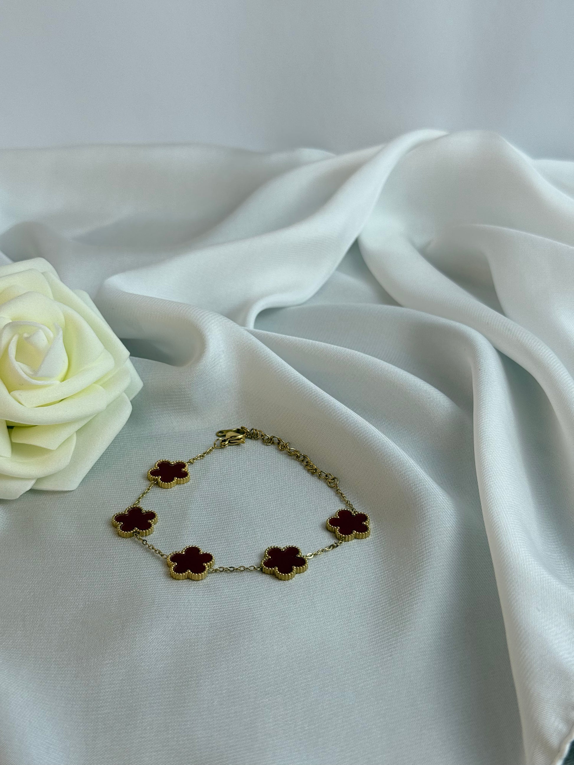 Bracelet with flower-shaped charms on a white fabric background