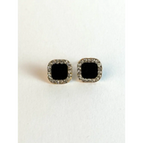 Pair of square black gemstone earrings with silver borders on a white background