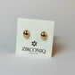 Gold earrings on a Zirconiq branded card against a light gray background