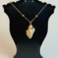 Necklace with a stone pendant on a black bust against a white background