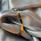 Gold bracelet on a soft gray fabric background